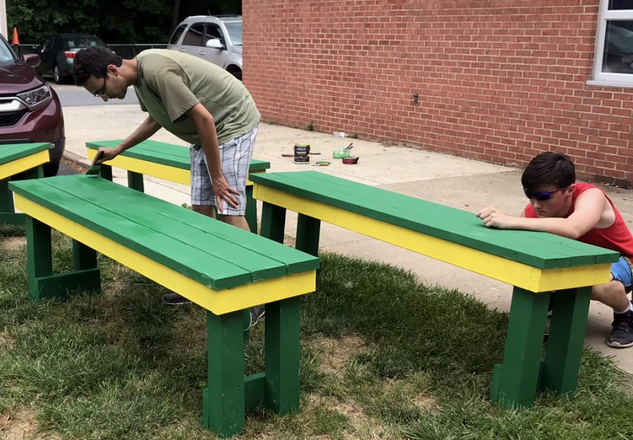 Two of Loudoun Valleys seniors painting benches for their capstone project