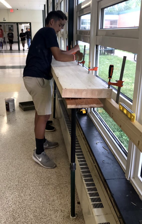 Two of Loudoun Valleys students constructing tables in the hallway