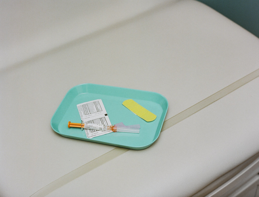 Vaccine on a tray with swabs and a band-aid by SELF Magazine is licensed with CC BY 2.0