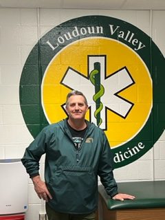 Andy Gordon poses in front of the Sports Medicine mural. 