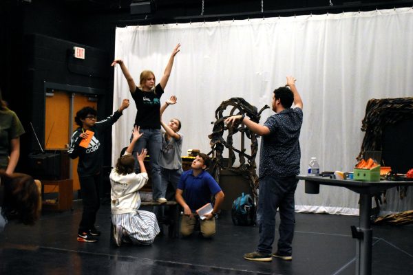 Senior Sydney Sheehan and the cast of "The Legend of Sleepy Hollow" rehearse making a tree shape to be silhouetted during the final performance