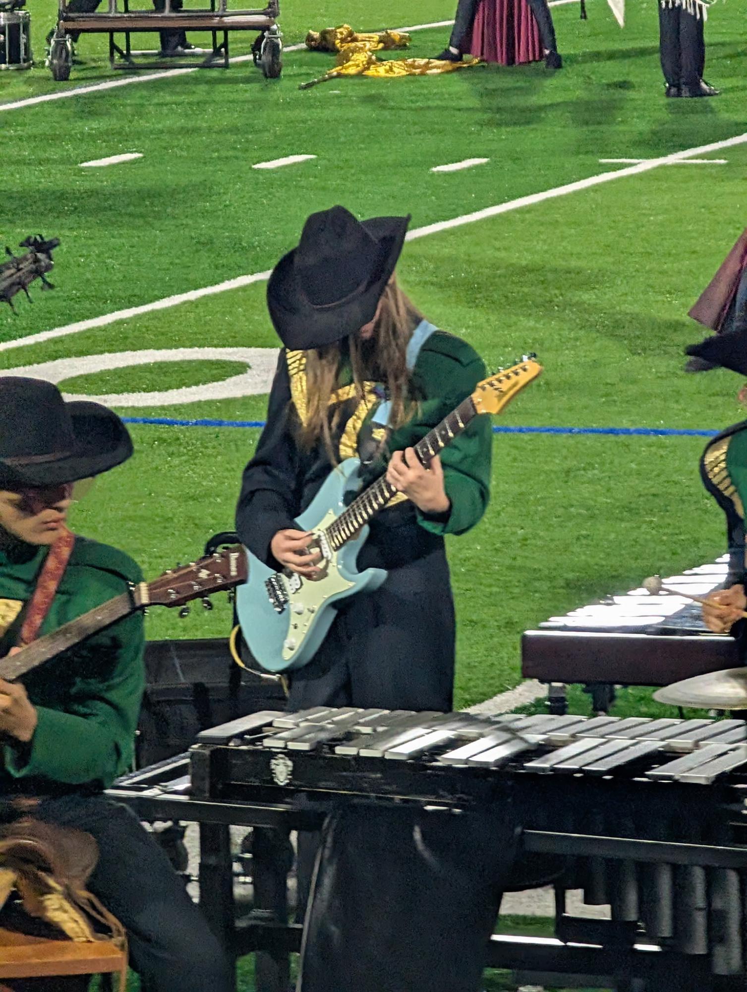 Staff Reporter sophomore Sam Waters plays her guitar, Izzy, in the marching band, Oct. 17
